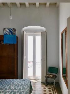 カディスにあるApartamentos La Selvaのベッドルーム1室(ベッド1台、窓、椅子付)