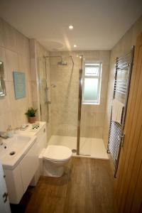 a bathroom with a shower and a toilet and a sink at Lovely two bedroom bungalow with hot tub in Yeovil