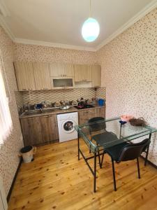 eine Küche mit einem Glastisch in einem Zimmer in der Unterkunft Nasimi Villa in Qəbələ