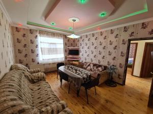 ein Wohnzimmer mit einem Sofa und einem Tisch in der Unterkunft Nasimi Villa in Qəbələ