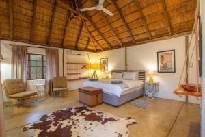 a bedroom with a bed and a chair and a table at South Safari Lodge in Marloth Park