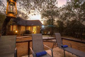 a group of chairs and a table in front of a house at South Safari Lodge in Marloth Park