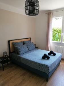 1 dormitorio con 1 cama con 2 toallas negras en Gîte Les Demoiselles des Sorgues, en LʼIsle-sur-la-Sorgue