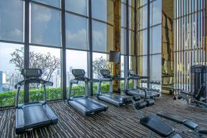 a gym with a row of tread machines in a building at Luxury 1Bed 1Bath 300m BTS Phrom Phong, Emporium EmSphere EmQuartier in Bangkok