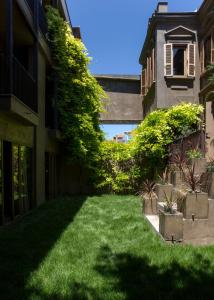 un patio con césped verde y un edificio en Life Gallery Hotel, en Korçë