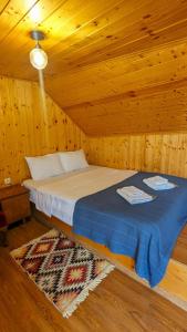 a bedroom with a bed in a wooden cabin at Levanto in Mtskheta