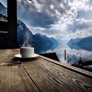 a cup of coffee sitting on a table with a view of mountains at Appartamento con la vista in Oltre il Colle