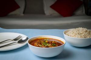 een kom soep en rijst op een tafel bij Hotel Town and country inn ( a unit of GS RESIDENCY) in Guwahati