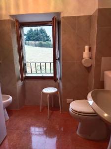 a bathroom with a toilet and a sink and a window at Appartamento con la vista in Oltre il Colle