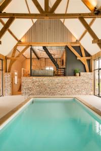 an indoor pool in a house with a brick wall at Hoeve-C in Ieper