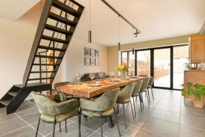a dining room with a long table and chairs at Hoeve-C in Ieper