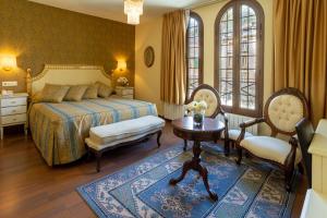 a bedroom with a bed and a table and chairs at Hotel de Camprodón in Camprodon