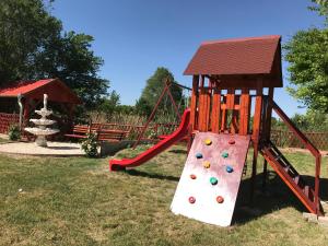 a playground with a slide and a tower at Tó-Party Apartman in Kiszombor
