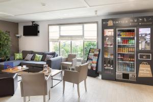a store with a couch and a table and a refrigerator at Campanile Morangis Orly in Morangis