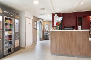 a restaurant with a counter in the middle of a room at Campanile Morangis Orly in Morangis