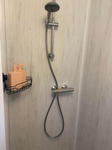 a shower with a hose attached to a wall at Caravan Weidezicht in Den Burg