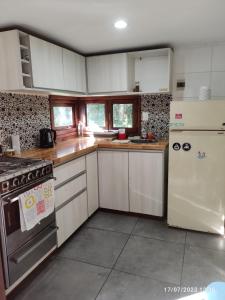 una cocina con electrodomésticos blancos y encimeras de madera en Cabaña UMA - Rumi Huasi en Mar del Plata
