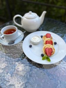 a plate of food with fruit and a cup of tea at Grand Christer Hotel in Kyiv