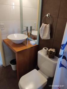 y baño con lavabo, aseo y espejo. en Cabaña UMA - Rumi Huasi en Mar del Plata