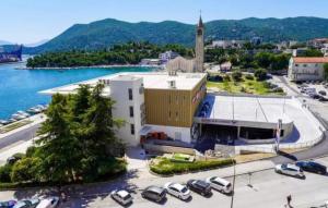 a large building with cars parked in a parking lot at Apartment Tina in Ploče