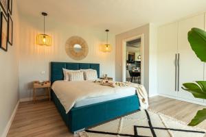 sypialnia z niebieskim łóżkiem i lustrem w obiekcie Lamelove Apartments w mieście Chocznia