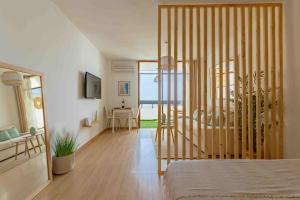 a room with a bed and a living room with a table at Dunas House Playa del Inglés in San Bartolomé +23 photos