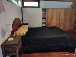Dormitorio pequeño con cama y mesa en Cabaña UMA - Rumi Huasi en Mar del Plata