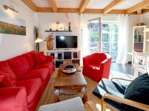 uma sala de estar com sofás vermelhos e uma televisão em Fachwerkhäuser Seedorf - Haushälfte "Lena Victoria" mit Kamin em Sandort