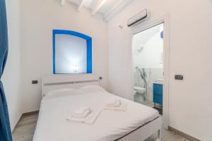 una camera da letto con un letto bianco e uno specchio blu di Rapallo Seaside Dream! Lovely Studio a Rapallo