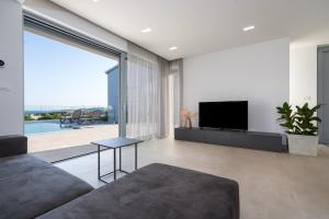 un soggiorno con divano e TV a schermo piatto di Luxury semidetached villa Smokva 1 - near the center and sea - by TRAVELER tourist agency Krk a Krk
