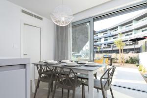 una sala da pranzo bianca con tavolo e sedie di Luxury semidetached villa Smokva 1 - near the center and sea - by TRAVELER tourist agency Krk a Krk