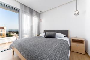una camera da letto con un letto e una grande finestra di Luxury semidetached villa Smokva 1 - near the center and sea - by TRAVELER tourist agency Krk a Krk Altre 37 foto