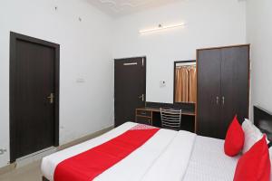 1 dormitorio con 1 cama grande con almohadas rojas en OYO Flagship 24199 Hotel Mid Town Ojus Tower, en Rudrapur