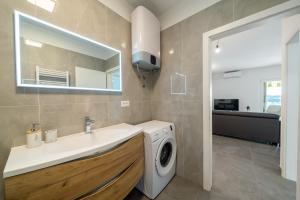 a bathroom with a washing machine and a sink at Apartments Siesta in Sumartin