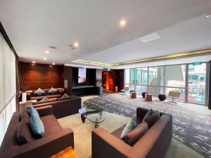 duży salon z kanapami i telewizorem w obiekcie Park Regis Singapore w Singapurze