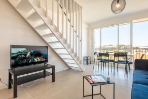 a living room with a tv and a staircase at Giens - Vue mer / marais - Appartement refait à neuf in Hyères