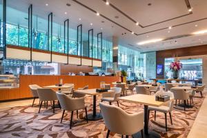 un coin repas avec des tables et des chaises dans un restaurant dans l'établissement Park Regis Singapore, à Singapour