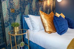 a bed with blue and gold pillows on it at Luxury Accommodation In The City Centre With Free Parking in Bournemouth