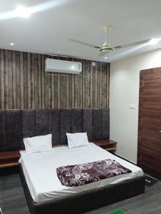 a bedroom with a large bed with a black headboard at OYO Hotel Orvin In in Jabalpur