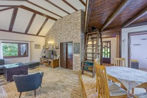 a living room with a stone wall and a table and chairs at Wellness House On The River Kupa - Happy Rentals in Banska Selnica