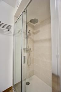 La salle de bains est pourvue d'une douche avec une porte en verre. dans l'établissement L'Escale, à La Forêt-Fouesnant