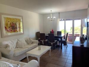 ein Wohnzimmer mit einem weißen Sofa und einem Tisch in der Unterkunft Casa con impresionantes vistas al mar in Tossa de Mar
