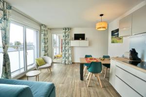 a kitchen and living room with a table and chairs at L'Escale in La Forêt-Fouesnant