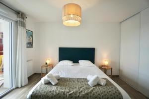 a bedroom with a large bed with two side tables at L'Escale in La Forêt-Fouesnant