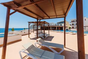 a row of lounge chairs on the beach at Bellevue Belsana in Portocolom