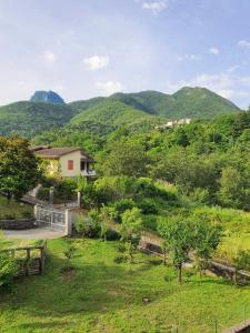 una casa en un campo con montañas en el fondo en Lunigiana vicino Equi Terme, en Monzone