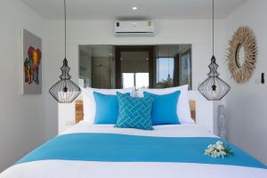 a bedroom with a blue and white bed with blue pillows at Zog Villas in Koh Samui 