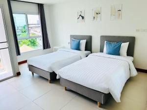 バンコクにあるThe Lodge @ Min Residenceの部屋に並んで置かれた2つのベッド +16枚の写真