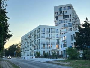 a large white building on the side of a street at Oxygen Residence in Neptun