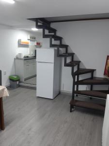 a living room with a staircase and a refrigerator at Apartament Magnolia Nearby City Center With Parking in Sibiu
